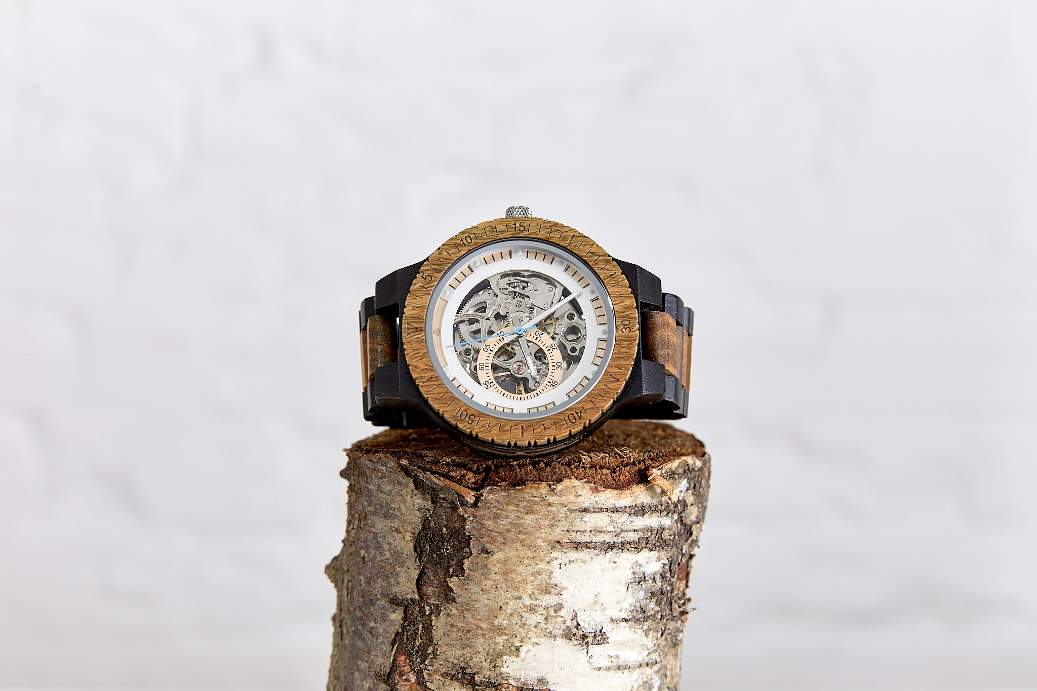 The Hemlock Sustainable natural wood wristwatch made from recycled wood by The Sustainable Watch Company placed on a log for display